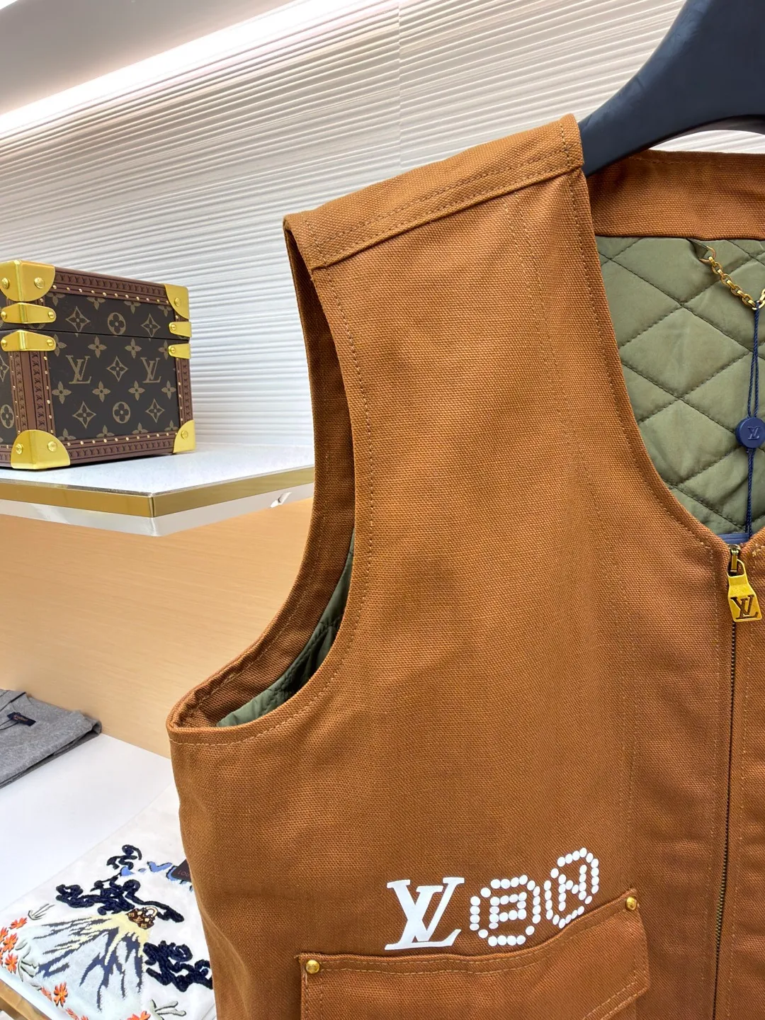 LOUIS VUITTON Nigo joint portrait work vest ●Original version: Purchased and developed for 16999 ●Item number: 1681331-B75 ●Fabric: denim fabric ●Technology: printing production ●Color: brown ●Version: fitted version ●Weight: about 785 grams ●Size: S-M-L-XL ●Description: Made of high-quality brown twill fabric, the texture is crisp and wear-resistant. The stability and texture of the fabric are ensured through fine weaving technology, which provides good support for the vest. The brand logo embroidery on the left uses a combination of bead embroidery and thread embroidery. The beads are arranged regularly, the embroidery stitches are fine, the pattern has a strong three-dimensional effect, and it is perfectly integrated with the fabric, highlighting the brand's luxurious craftsmanship. It adopts three-dimensional tailoring to fit the human body shape, making it comfortable to wear and fashionable. Double-thread reinforcement technology is used during sewing, the seams are smooth and compliant, the stitch spacing is even, and the lines are straight, reflecting the exquisite level of garment making. The buttons on the pockets are custom-made metal buttons with a smooth surface and brand details, high-quality texture and strong durability; the zipper is also customized by the brand, with the zipper puller bearing the brand logo, and the zipper is smooth and easy to pull. The quilted lining on the inside not only increases the warmth of the vest, but also improves the overall sophistication. The quilting lines are regular and reflect the meticulous craftsmanship. The design of the large pockets is both practical and decorative, with neat stitching on the edges of the pockets; the lines of the neckline and body are simple and elegant, and the overall craftsmanship details reflect the brand's high-end production standards. The overall wiring is straight and delicate, the fabric is comfortable and soft, and the color is consistent without color difference. It can be matched with the same style to create a fashionable look and control various occasions. Customized accessories, complete with three standards, same style for men and women!